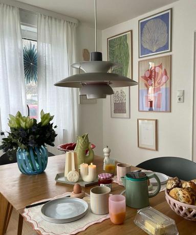 שולחן אוכל עם כלי אוכל צבעוניים ואמנות קיר