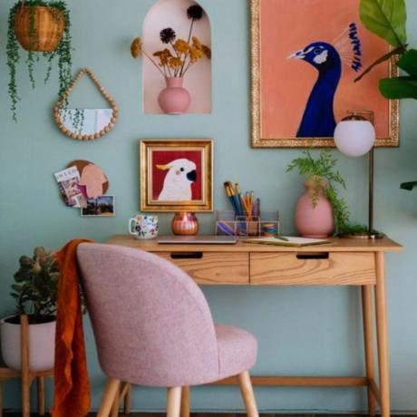 Sedia rosa alla scrivania in legno in ufficio blu