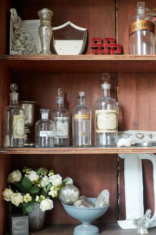 gabinete lleno de botellas de vidrio y otras curiosidades