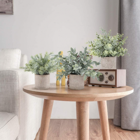 Et sæt med tre imiterede stueplanter på et sofabord.
