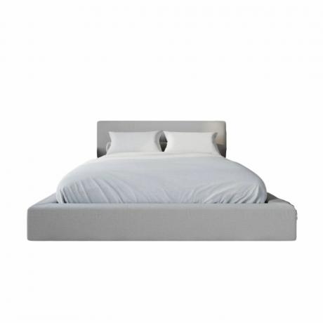 Un grand lit blanc avec deux oreillers et un matelas
