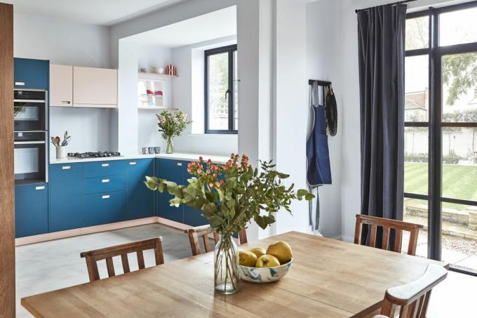 Åpen kjøkken-spisestue med mørkeblått kjøkken