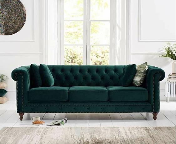 soggiorno con schema bianco e divano in velluto verde del supermercato di mobili in rovere