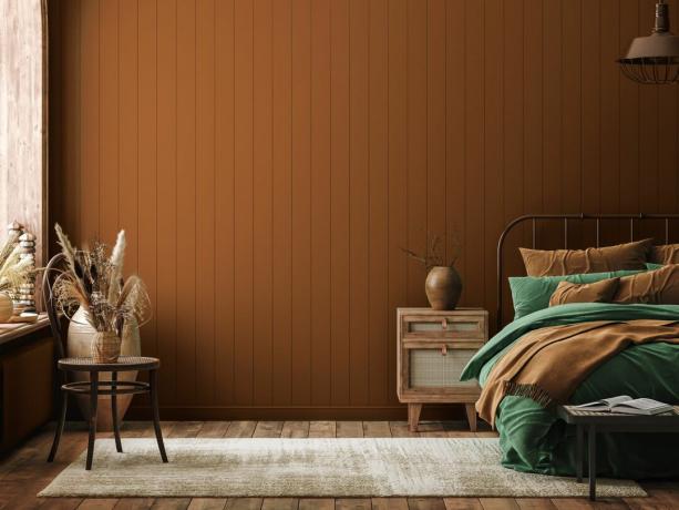 dormitor cu pereți lambriuri de teracotă și lenjerie de pat verde măsliniu