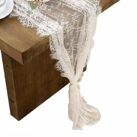 Ein Tischläufer aus Spitze auf einem Holztisch