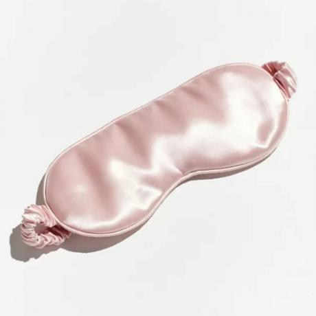 Una máscara para dormir de estilo satén rosa sobre un fondo blanco. 