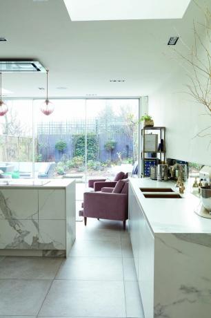 Vienstāva pagarinājuma projektēšana: marmora virtuve ar rozā atzveltnes krēsliem