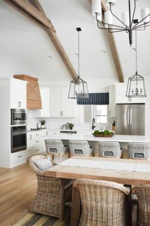 hvitt kjøkken med åpen planløsning, spisebord, hvelvet tak