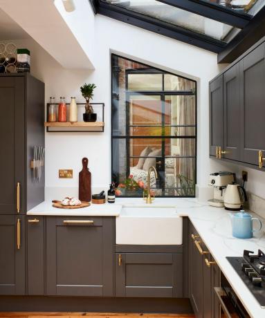 grijze keuken in shaker-stijl met gouden handgrepen en belfast-spoelbak