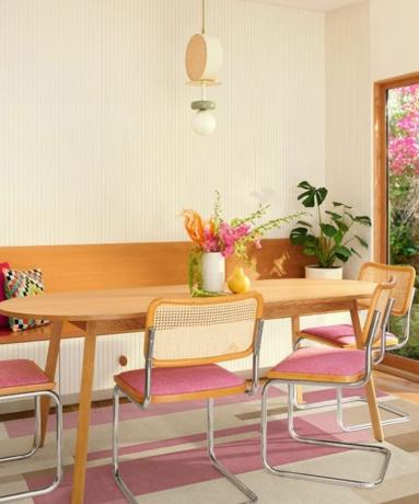 Valgomasis stalas su rožinėmis sėdynėmis ir rožiniu kilimėliu