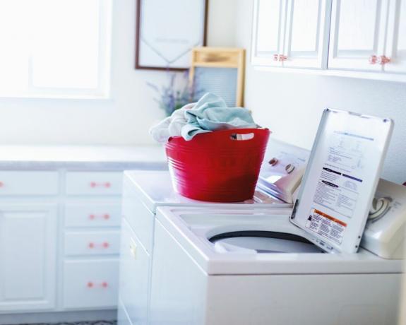 Üstten yüklemeli çamaşır makinesi bulunan çamaşır odası