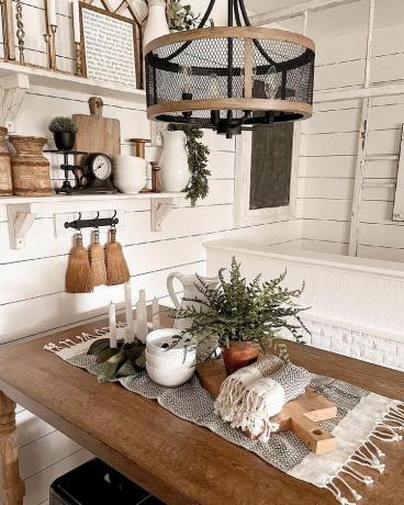 თეთრი სამზარეულო ხის მაგიდით და კედლის პანელებით