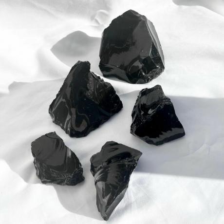 Zwarte obsidiaankristallen op een witte achtergrond