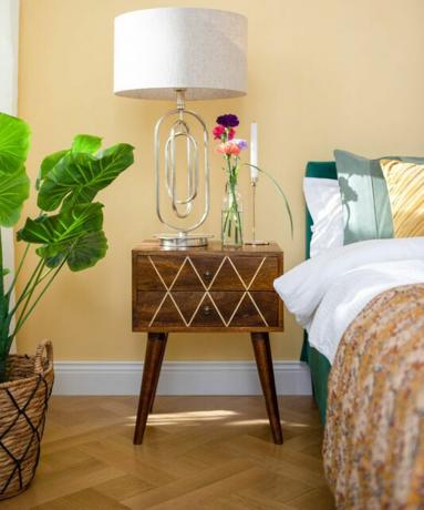 „Wayfair“ geltono miegamojo idėja su lova ir mediniais stalčiais