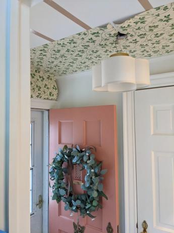 Teto de mudroom com papel de parede com porta rosa e coroa de flores