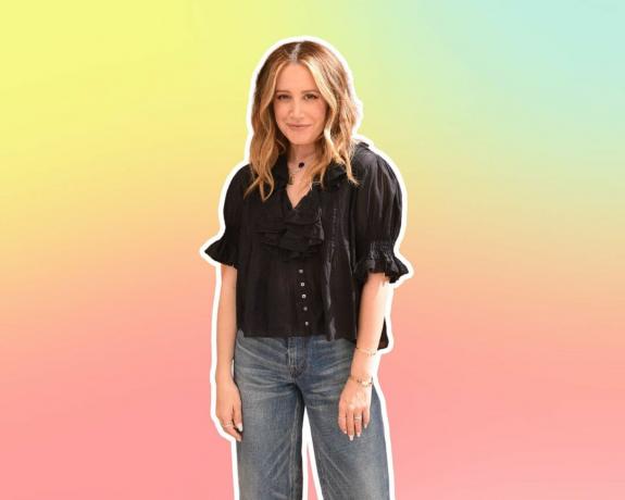 ashley tisdale i jeans och en svart topp på pastellbakgrund