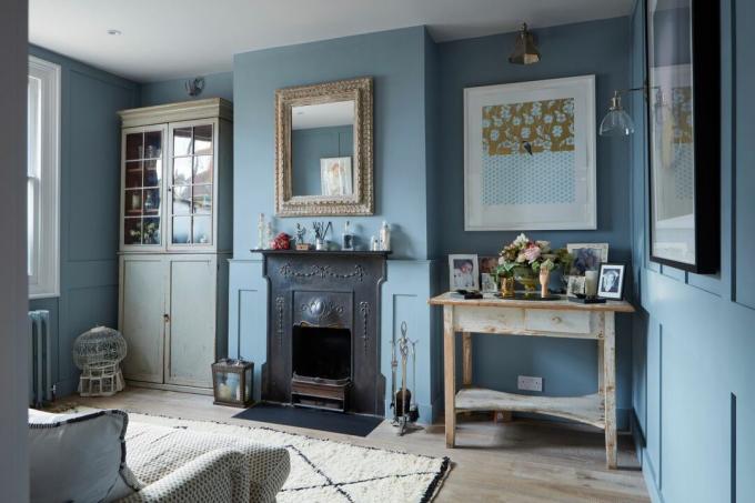 sala de estar azul con chimenea original y obras de arte en las paredes