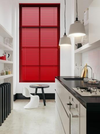 малка, тънка, бяла кухня със съвременна схема, с червени щори за прозорци, модерен стол и бар стол с английски щори