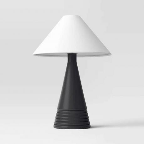 En svart konisk baslampa med vit lampskärm