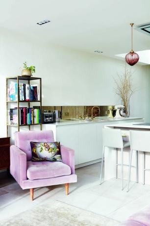 vaaleanpunainen samettinen nojatuoli valkoisessa keittiössä