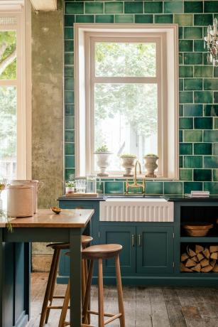 ბელფასტის ნიჟარა ან ბატლერის ნიჟარა დევოლის სამზარეულოში მუქი ლურჯი კაბინეტებით და მწვანე კრამიტით დაფარული კედლით