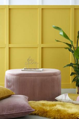 Ružičasti otonasti otoman sjedi ispred žute pozadine u trsci