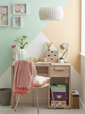 Mesa de madeira contra parede de bloco de cores geométricas