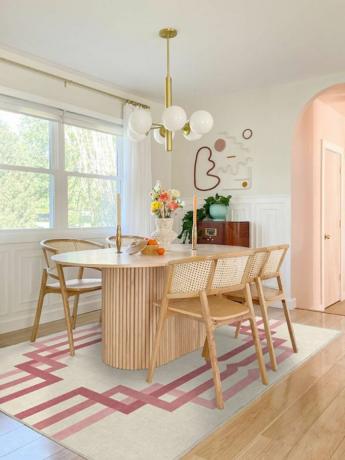 სასადილო ოთახი ხის სასადილო კომპლექტით და ვარდისფერი ხალიჩით