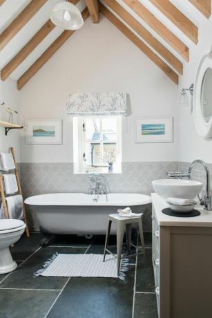 et nyt badeværelse i et renoveret hjem med hvælvet loft og fritstående badekar