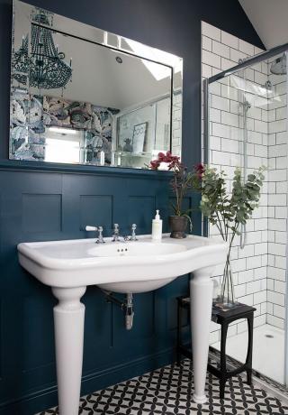 Waschbecken in einem Badezimmer mit kleinem Spiegel mit Wandverkleidung und Metrofliesen