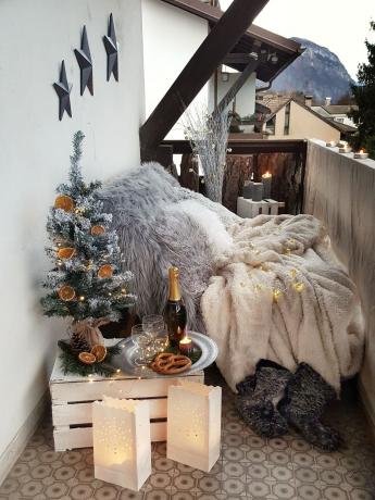 svečani balkon s puno sivih navlaka i jastuka i božićno drvce