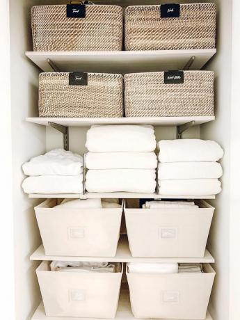Organiserad linneskåp med lådor på hyllor
