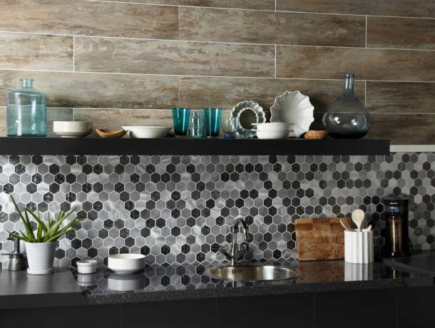 sorte, hvite og grå sekskantede backsplash -fliser i et mosaikkmønster på et mørkt kjøkken