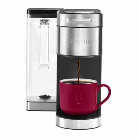 En silver och svart Keurig K-Supreme Plus kaffebryggare med en röd mugg på