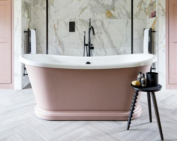 rosa badkar i krämfärgat badrum