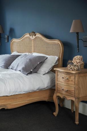 cama de ratán en dormitorio azul marino
