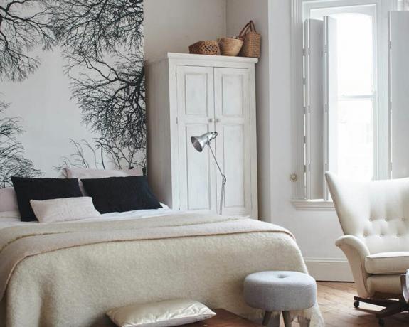 ein kleines Schlafzimmer mit Stehlampe und Wanddeko – China Cooper