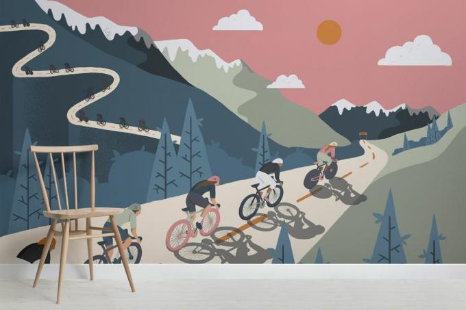 kuntosalin seinämaalaus, jossa pyöräilijät pyöräilevät vuorten halki