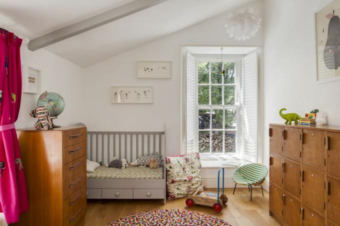 barns sovrum med spjälsäng och fönster