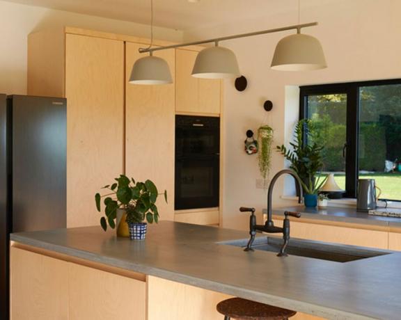 Ada ve lavabo ve minimal estetik ile sıcak nötr çağdaş mutfak düzeni