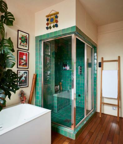 salle de douche carrelée verte avec baignoire et plante