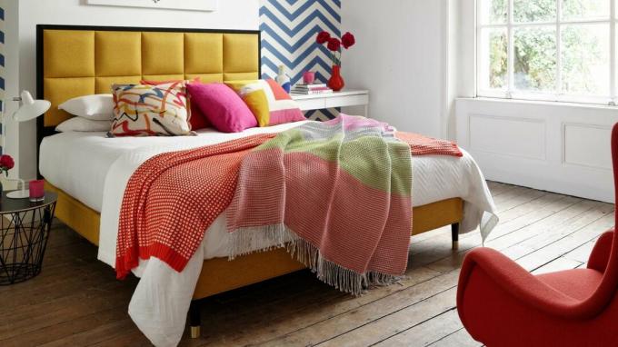Dormitorio con cama con cabecero amarillo tapizado