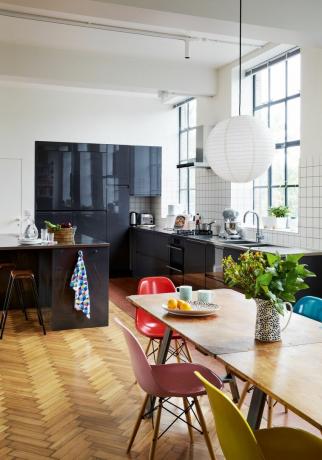 Carlo Viscione: cucina in stile industriale con elementi blu scuro, pavimento in parquet e alzatina bianca a griglia