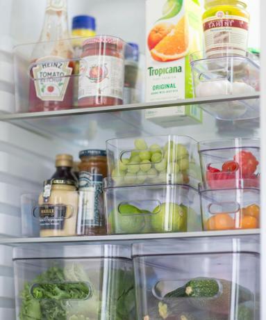 फ्रिज में पारदर्शी प्लास्टिक के डिब्बों के अंदर भोजन की व्यवस्था