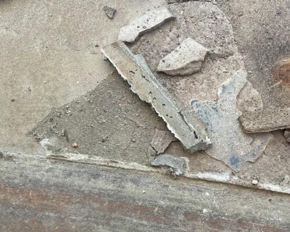 старо засъхнало лепило за плочки и фугираща смес на пода след отстраняването на подовите плочки