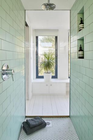 민트 그린 벽 타일과 흰색 바닥 타일로 마감된 실내 욕실/샤워실