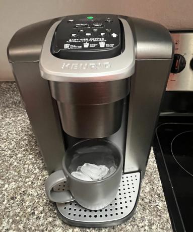 Keurig K-Elite เครื่องชงกาแฟแบบเสิร์ฟเดี่ยวพร้อมเหยือกสีเทาที่เต็มไปด้วยก้อนน้ำแข็งเพื่อเตรียมเครื่องดื่มกาแฟเย็น