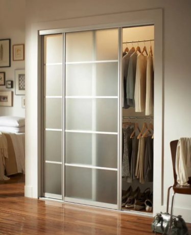Marco de aluminio de níquel cepillado Puerta corrediza interior de vidrio Mystique sobre el armario en el dormitorio con pisos de madera pulida
