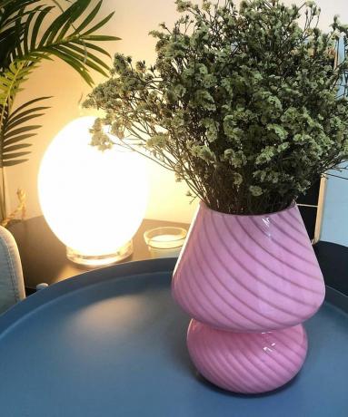 Lampu meja di samping vas bunga