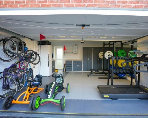 Гаражна домашна фитнес зала с шкафове за съхранение и велосипеди